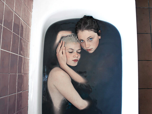 Dos jóvenes en una bañera con agua oscura
